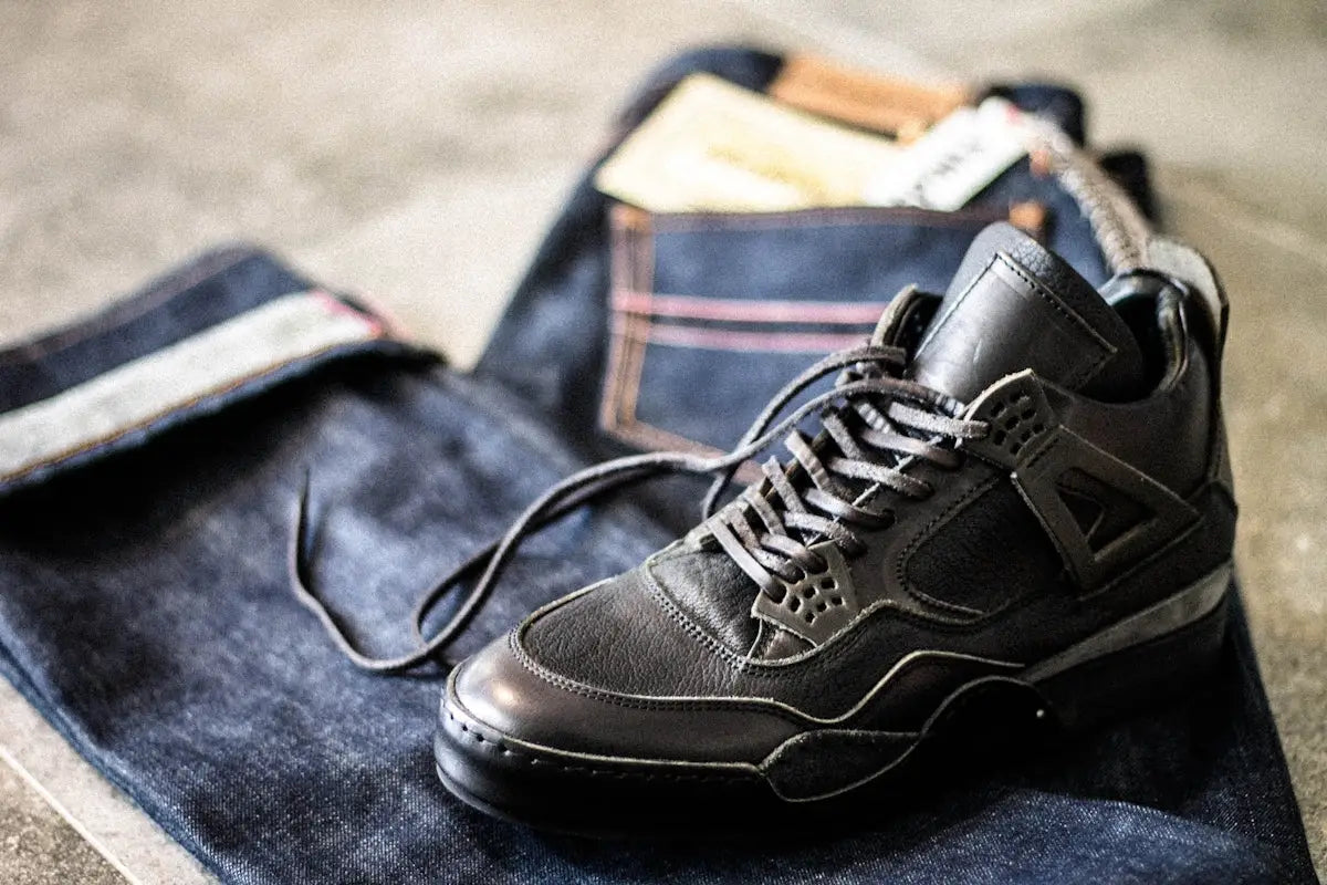 Black leather high-top sneaker with a sleek, modern design and subtle gray accents on the sole.