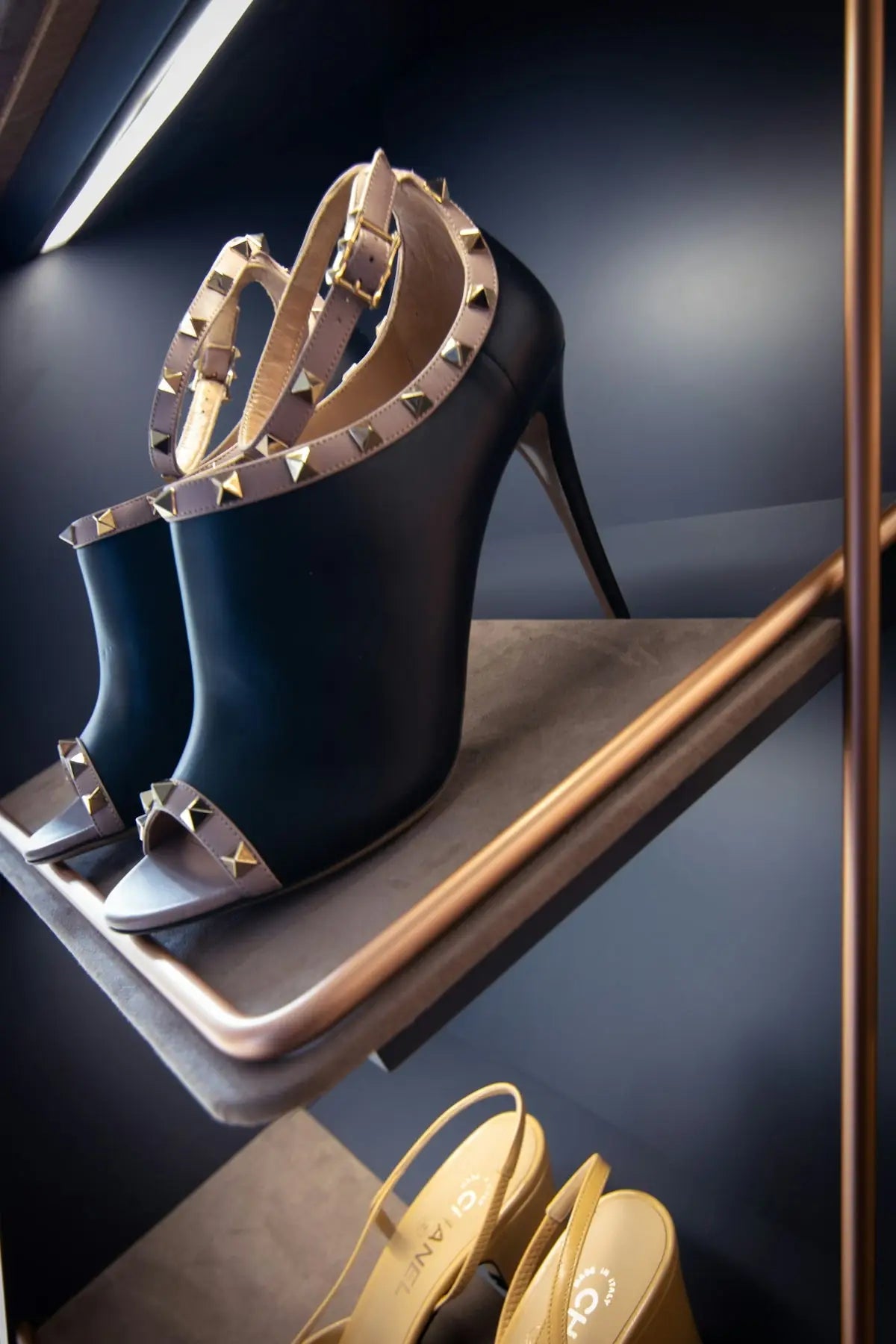 Black leather valentino rockstud high-heeled sandals with gold-tone pyramid studs.