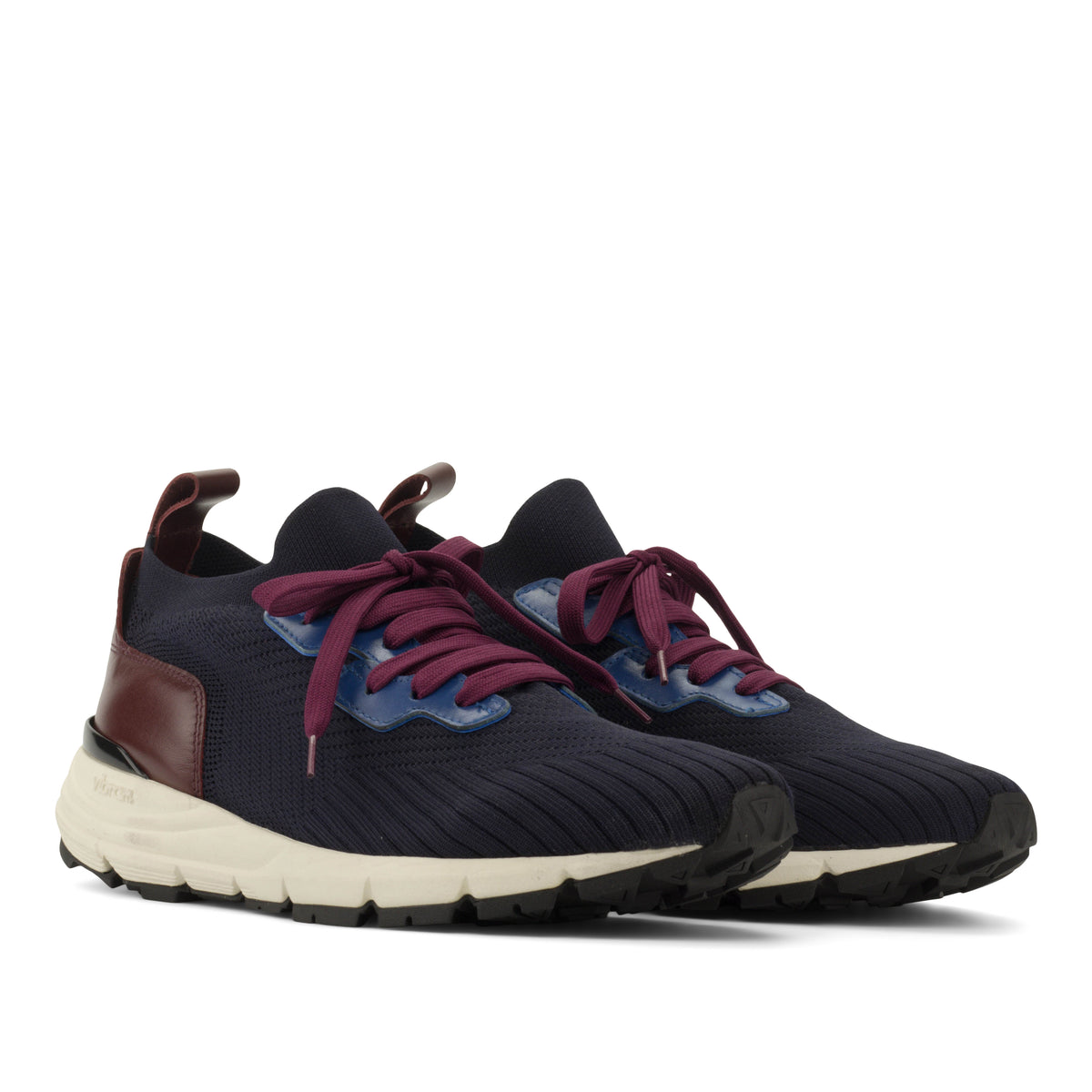 A pair of athletic sneakers in navy blue knit with burgundy laces, burgundy heel accents, and a cream midsole, shown against a plain white background.