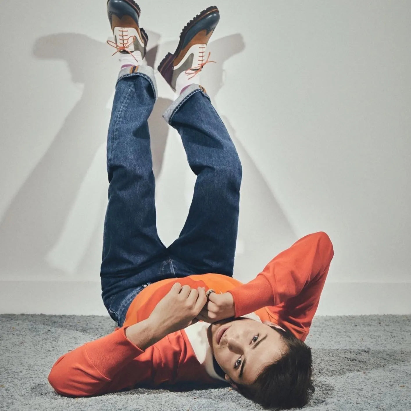 Person lying upside down in Eleanor unisex painted calf brogue shoes