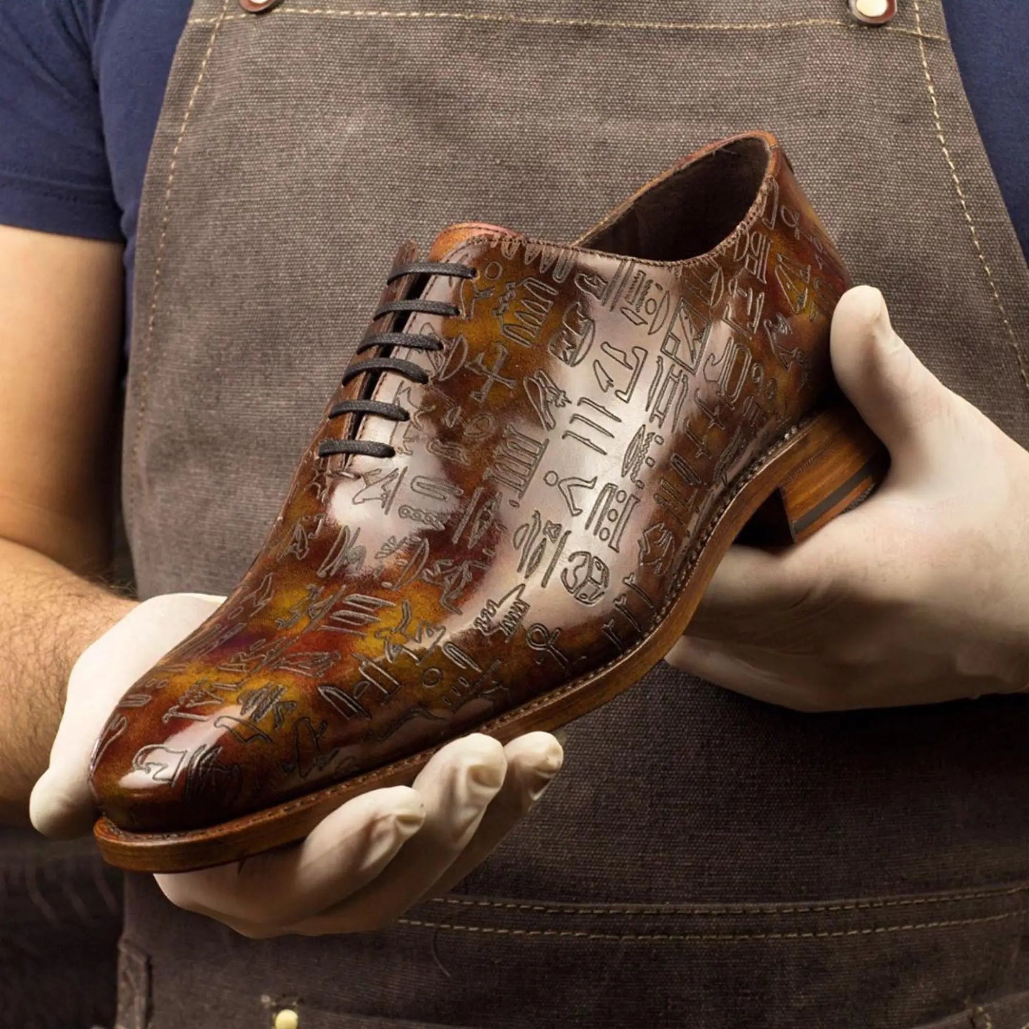 Brown leather shoe with hieroglyphics.